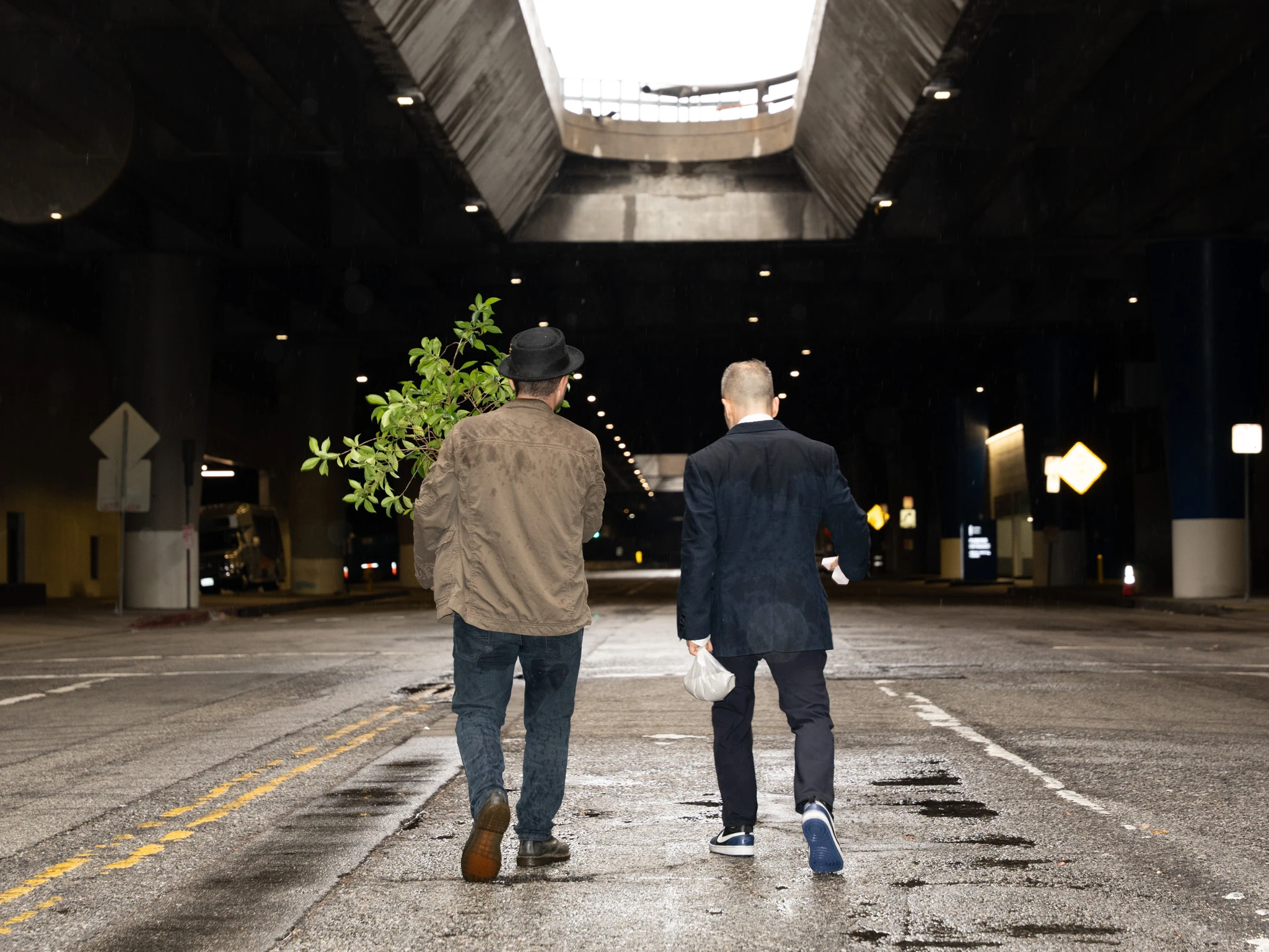 Dan and Marty walking away into a Los Angeles tunnel with their backs to the camera, in black and white