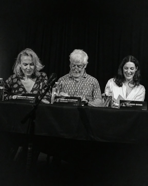 Members of the cast seated together at the table read