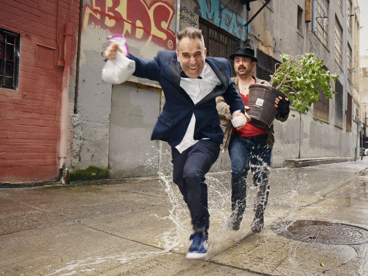 Ben Giroux and Arnie Pantoja leaping over a puddle in a Los Angeles alley